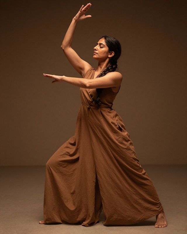 Dancer in a flowing dress moving freely at sunset by the sea